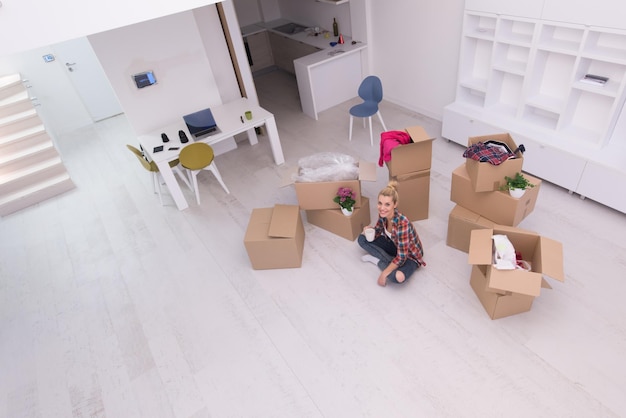 pessoas, mudando de lugar e conceito de reparo feliz linda jovem com muitas caixas de papelão sentadas no chão com Copa em casa