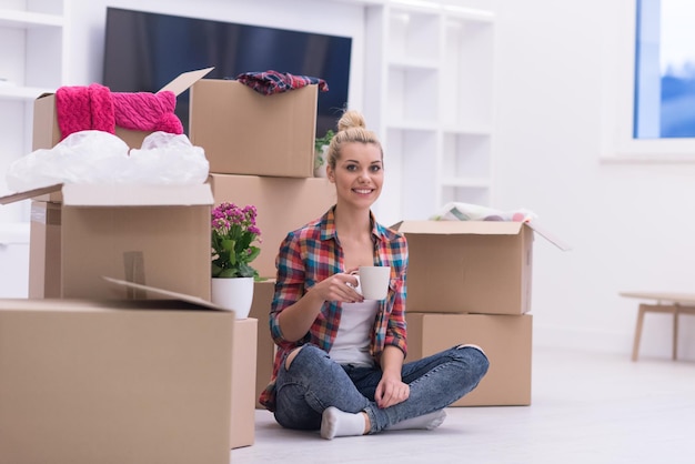 pessoas, mudando de lugar e conceito de reparo feliz linda jovem com muitas caixas de papelão sentadas no chão com Copa em casa