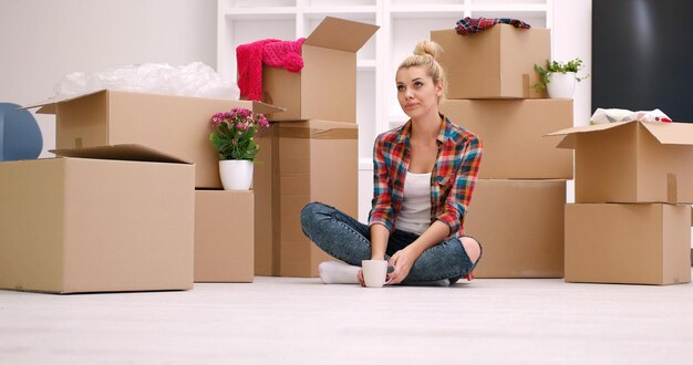 pessoas, mudando de lugar e conceito de reparo feliz linda jovem com muitas caixas de papelão sentadas no chão com Copa em casa