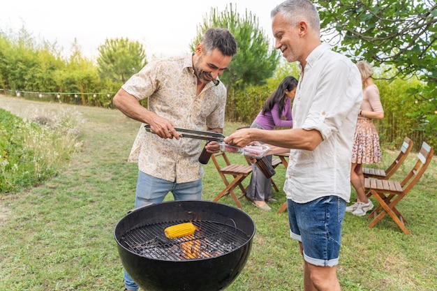 Pessoas multirraciais ao redor do churrasco sorrindo felizes e rindo juntos conceito de alegria