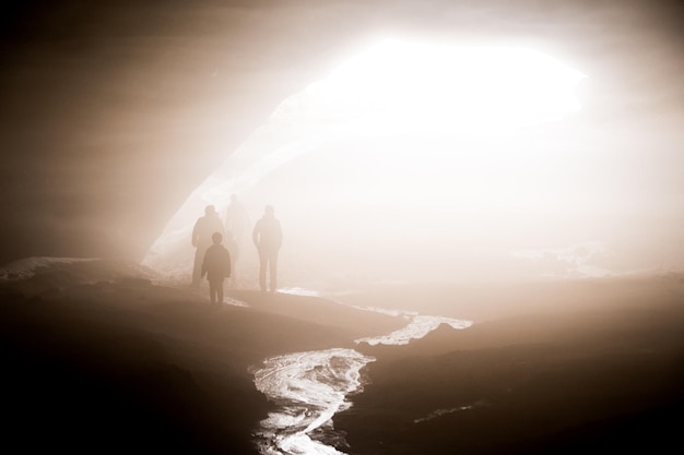 Foto pessoas na montanha contra o sol brilhante