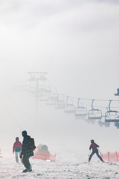 Pessoas na pista de esqui aprendendo a montar o resort de inverno das famílias