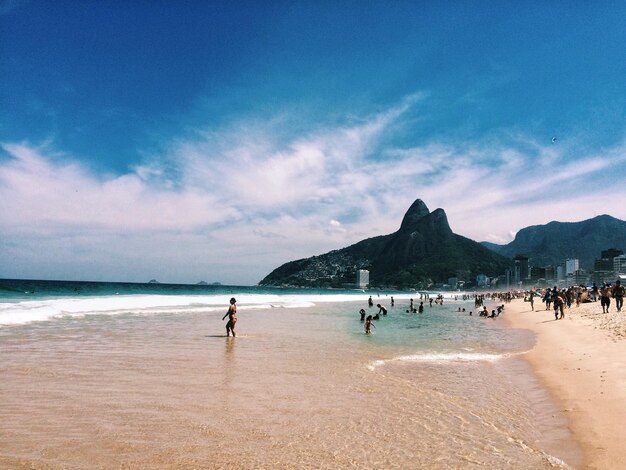 Foto pessoas na praia contra o céu azul