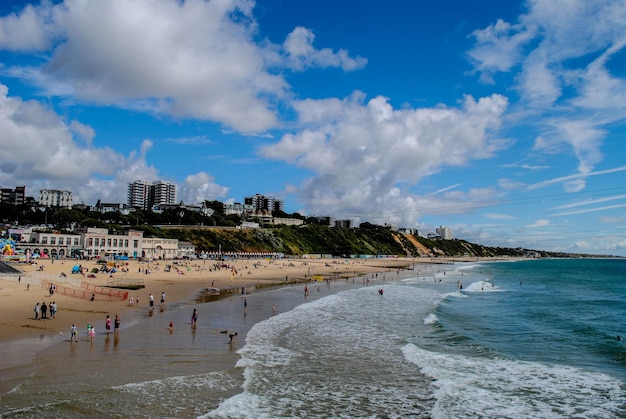 Pessoas na praia contra o céu nublado