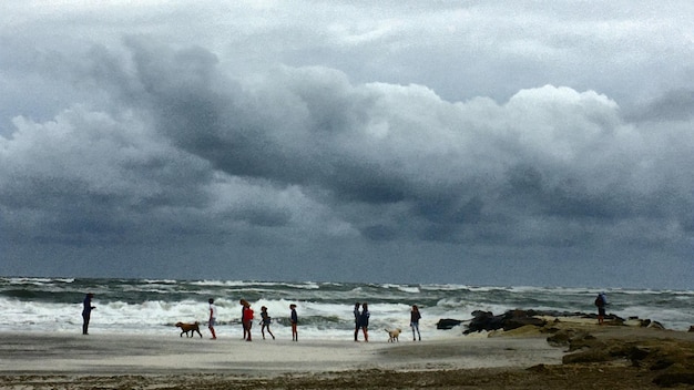 Foto pessoas na praia contra o céu