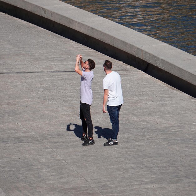 pessoas na rua tirando fotos com um smartphone na cidade de Bilbao, Espanha