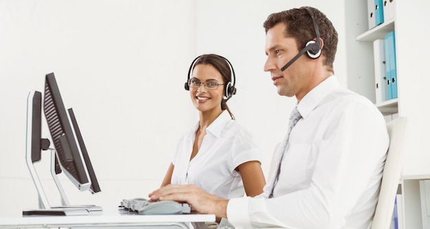 Pessoas negócio, com, headsets, usando, computadores, em, escritório