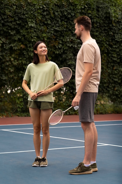 Pessoas no campo de badminton tiro completo