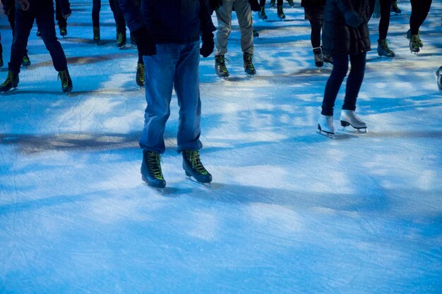 Pessoas patinando no gelo imagem recortada mostrando as pernas das pessoas