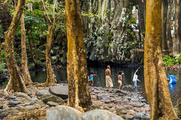 Pessoas perto de rochester falls, na ilha de maurício. uma cachoeira na selva da ilha tropical de maurício.