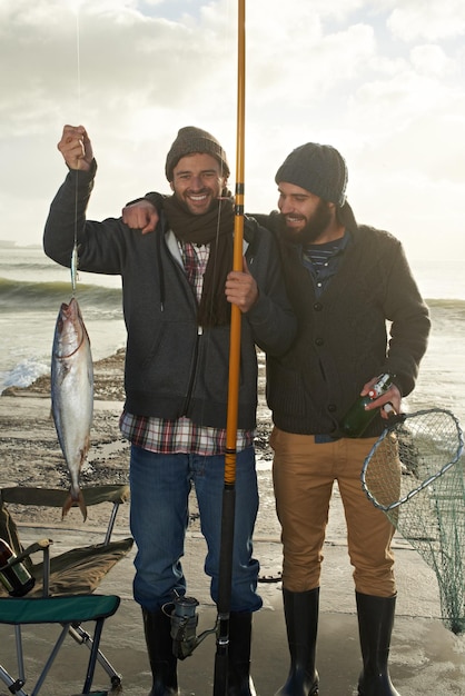 Foto pessoas pescando e retrato feliz no lago com orgulho para pegar truta com ferramentas no cais em férias amigos pescadores e sorriso segurando peixe na mão em aventura na natureza no mar para férias