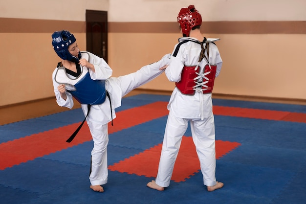 Pessoas praticando taekwondo em um ginásio