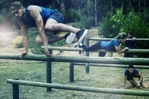 Foto pessoas pulando obstáculos durante a pista de obstáculos