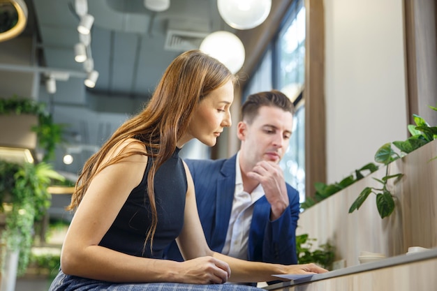 Pessoas que trabalham em startups Dois empresários sorrindo e fazendo brainstorming enquanto usam laptopxA