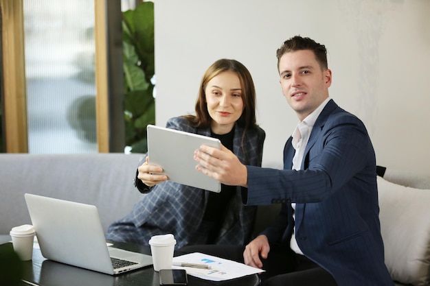 Pessoas que trabalham em startups Dois empresários sorrindo e fazendo brainstorming enquanto usam laptopxA