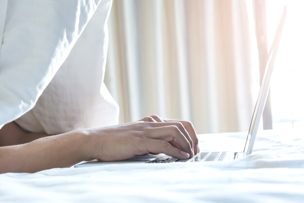 Pessoas que trabalham na cama com Laptop de manhã