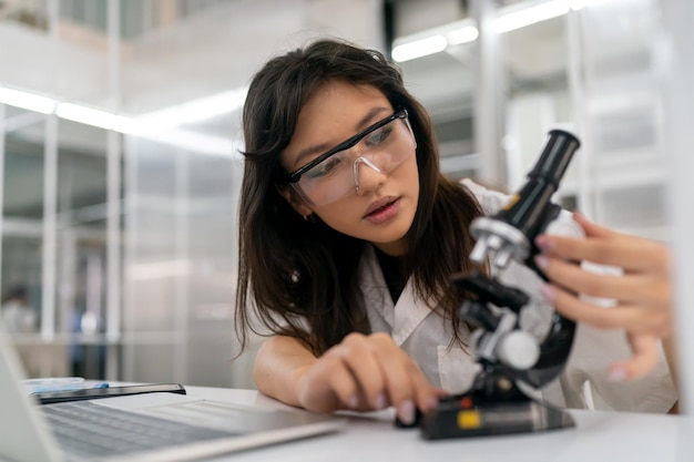 Pessoas que trabalham no laboratório usando lupa no microscópio