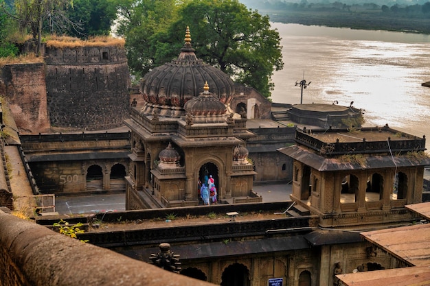 Pessoas realizam adoração matinal no forte e templo de Maheshwar no rio sagrado Narmada em Maheshwar Madhya Pradesh Índia