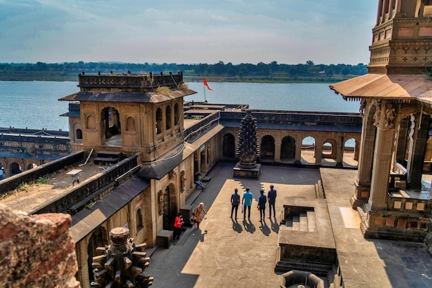 Pessoas realizam adoração matinal no forte e templo de Maheshwar no rio sagrado Narmada em Maheshwar Madhya Pradesh Índia