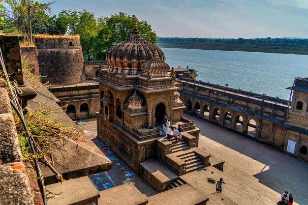 Pessoas realizam adoração matinal no forte e templo de Maheshwar no rio sagrado Narmada em Maheshwar Madhya Pradesh Índia