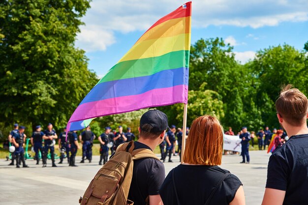 Pessoas se aglomeram com bandeiras de arco-íris LGBTQ em demonstração de orgulho