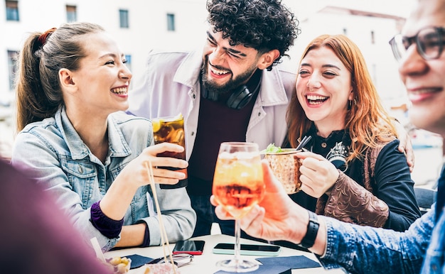 Pessoas se divertindo bebendo em um bar ao ar livre no happy hour - conceito de estilo de vida com jovens amigos passando um tempo juntos conversando e compartilhando coquetéis na calçada da cidade - Filtro plano vintage