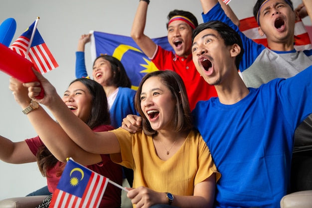 Pessoas segurando a bandeira da malásia comemorando o dia da independência
