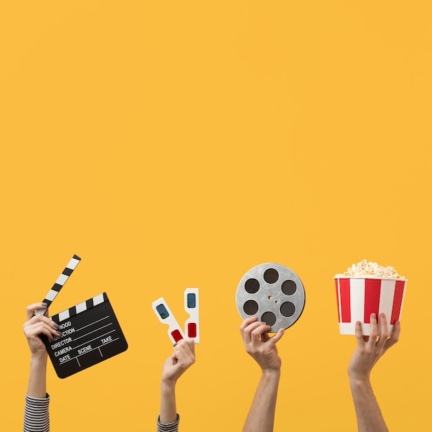 Foto pessoas segurando elementos do filme com espaço de cópia