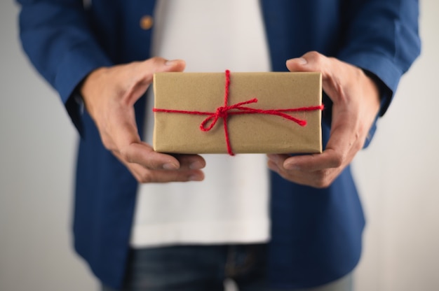 Pessoas segurando uma caixa de presente, caixa de presente de ano novo, caixa de presente de Natal, espaço de cópia. Natal, ano de vida, conceito de aniversário.