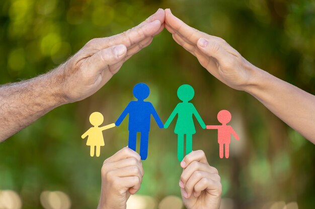 Foto pessoas segurando uma família de papel nas mãos