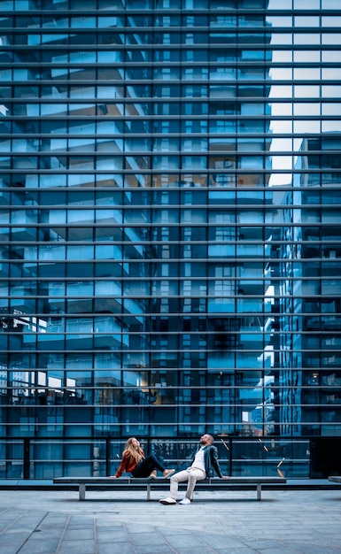 Foto pessoas sentadas contra edifícios modernos na cidade