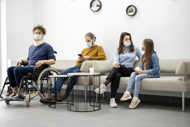 Pessoas sentadas no corredor da clínica à espera de uma consulta