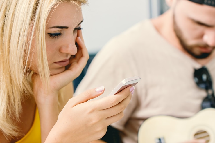 Foto pessoas sérias acompanham a atualização de notícias sobre o surto do vírus corona com uma expressão séria no celular.