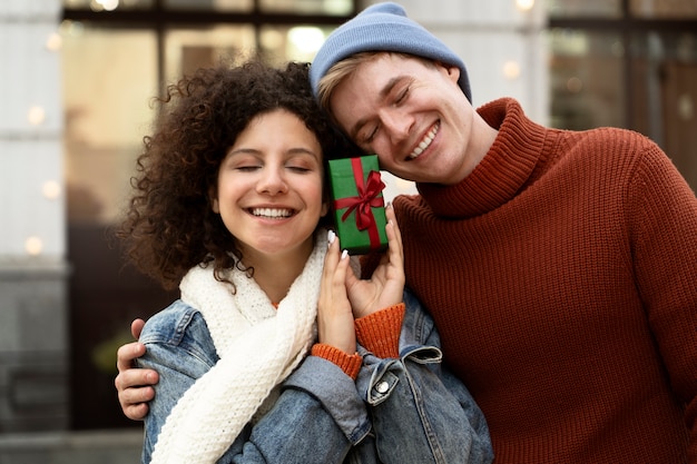 Pessoas sorridentes de tiro médio com presente