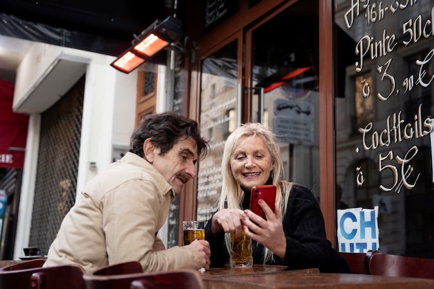 Foto pessoas sorridentes de tiro médio olhando para o telefone