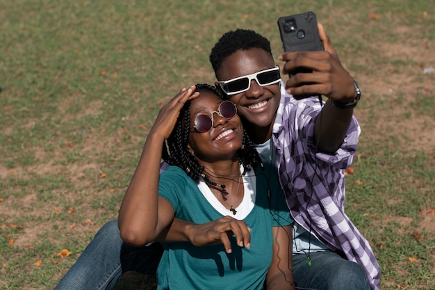 Pessoas sorridentes em tiro médio tirando selfie