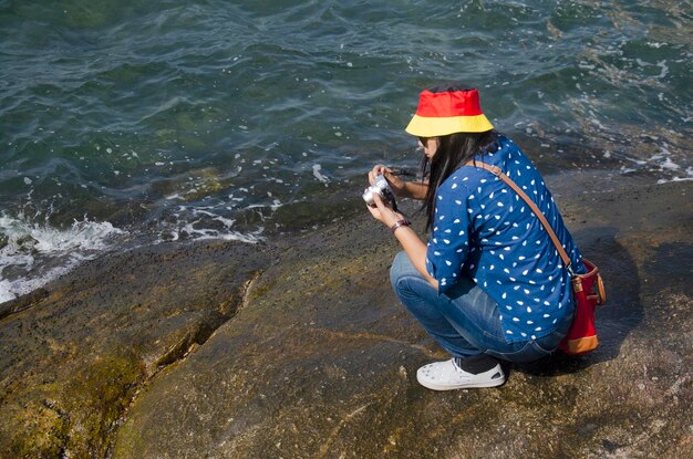 Pessoas tailandesas posando para tirar foto na rocha no mar em Laem Thaen Cape em Bang Saen Beach em Chonburi Tailândia