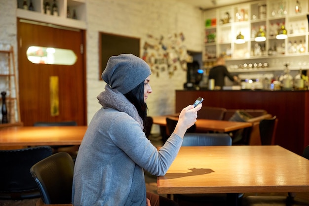 pessoas, tecnologia e conceito de estilo de vida - jovem sorridente com smartphone no café