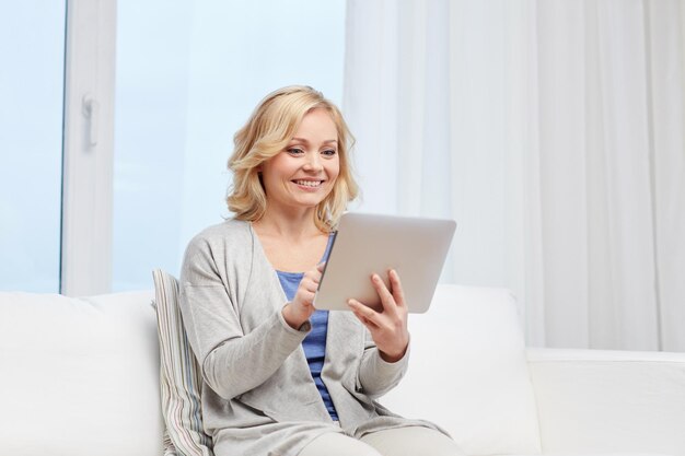 pessoas, tecnologia e conceito de internet - mulher de meia-idade feliz com computador tablet pc em casa