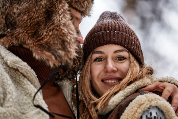 Pessoas temporada amor e conceito de lazer casal feliz abraçando e rindo ao ar livre no inverno Casal abraçando e se divertindo no parque de inverno nevado