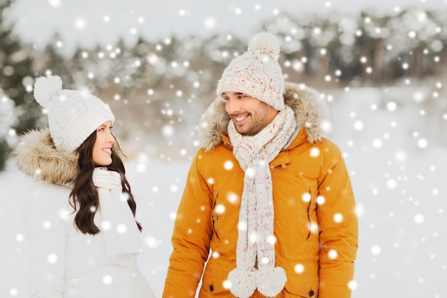 pessoas, temporada, amor e conceito de lazer - casal feliz andando sobre fundo de inverno