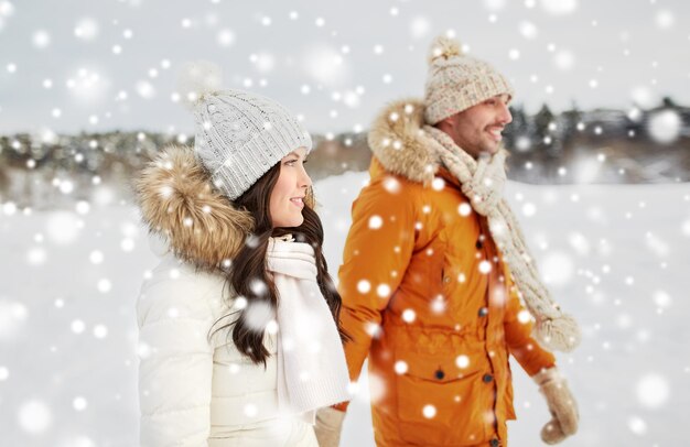 pessoas, temporada, amor e conceito de lazer - casal feliz andando sobre fundo de inverno