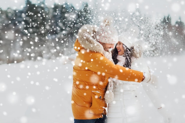 pessoas, temporada, conceito de amor e lazer - casal feliz abraçando e rindo ao ar livre no inverno