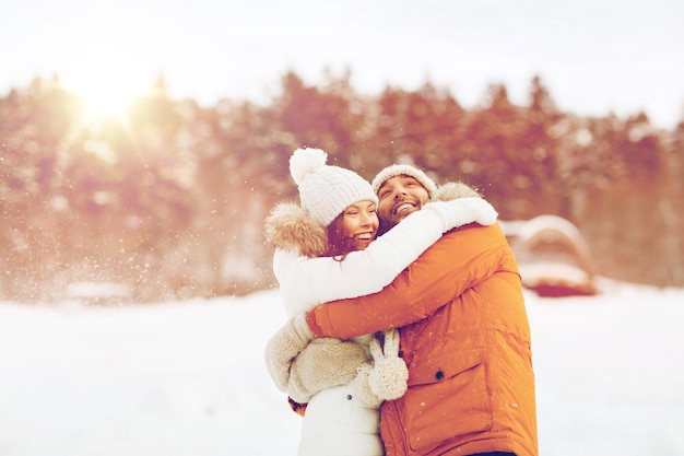 pessoas, temporada, conceito de amor e lazer - casal feliz abraçando e rindo ao ar livre no inverno