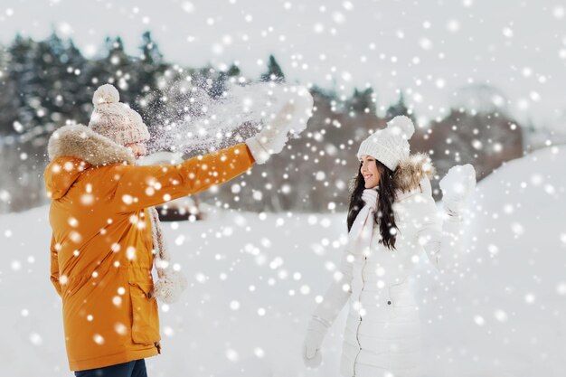 pessoas, temporada, conceito de amor e lazer - casal feliz brincando com neve no inverno