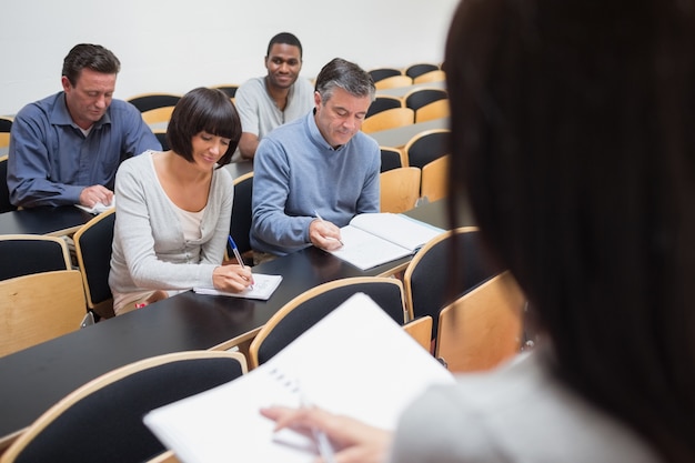 Foto pessoas tomando notas na aula