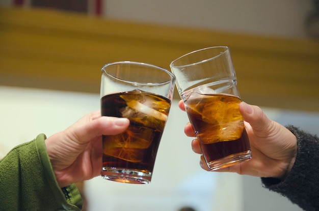 Pessoas torcendo com óculos refrescantes de cola gelada dentro de casa