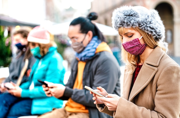 Pessoas usando smartphone coberto pela máscara na segunda onda da Covid