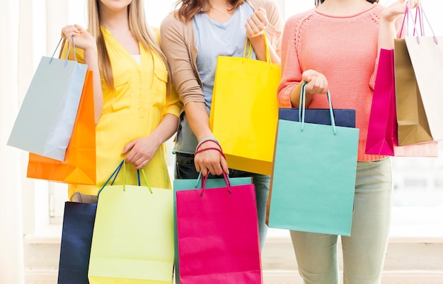 pessoas, venda, consumismo e conceito de estilo de vida - close-up de adolescentes felizes ou mulheres jovens com sacolas de compras