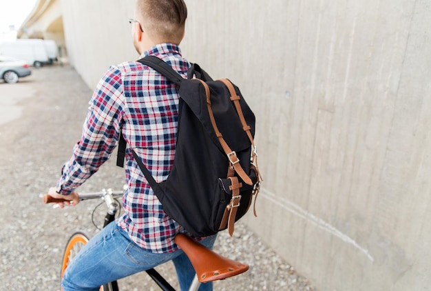 pessoas, viagens, turismo, lazer e estilo de vida - homem jovem hipster com bicicleta de engrenagem fixa e mochila na rua da cidade